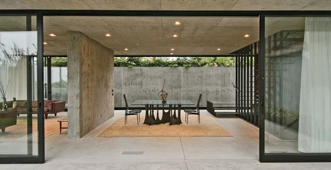 On the main level, sliding glass walls retract to create a seamless at-grade transition between indoors and out.