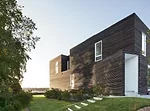 The dark exterior of the 2,200-square-foot house is clad in custom-milled slats of cypress. Each 1 1/2”-by-3” slat has been charred, brushed, and oiled.