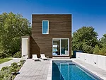 The east facade serves as the entry and faces the pool and separate garage.