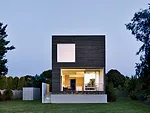 An elevated deck for outdoor dining is tucked below the main bedroom and includes an open-air skylight.