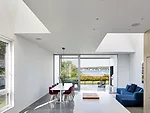 Large cutouts in the ceiling flood the ground-floor public space with natural light as it overlooks Quonochontaug Pond.