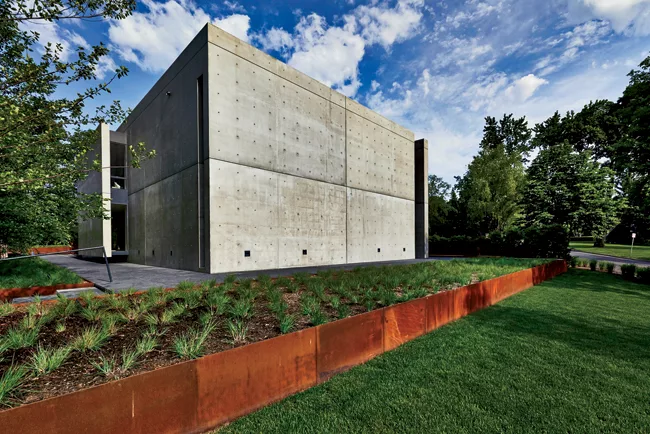 The house sits on a Cor-Ten–sided plinth, with landscape design by Andrea Cochran.