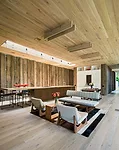 The large central space combines kitchen and dining with a casual sitting area. Light oak floors and ceilings contrast with the Western Red Cedar walls.