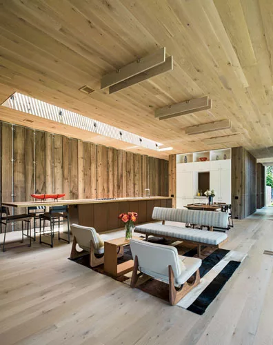 The large central space combines kitchen and dining with a casual sitting area. Light oak floors and ceilings contrast with the Western Red Cedar walls.