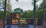The living and dining areas along the north side of the house adjoin a covered porch lined in board-and-batten.