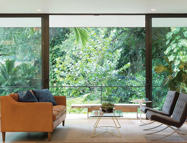 Inside, the open-plan interior has expansive views of the jungle-like setting.