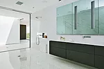 In the master-bathroom suite, his bath is one large shower room with drainage built into the terrazzo floor. 