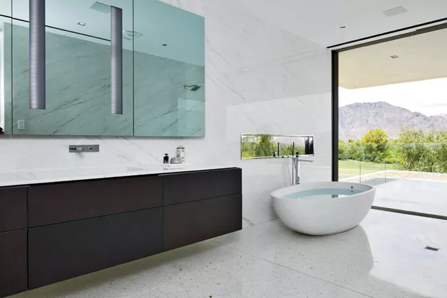 The marble-topped oak vanity spans 12 feet in length. Her bath features a freestanding egg-shaped tub with a rain shower just beside it. Glass pocket walls in both baths give way to outdoor terraces.