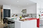 To introduce some color, Reddy created an ingenious modular bar—in a vibrant red—that glides in and out of the counter, extending the surface for serving and visually separating the kitche