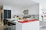 To introduce some color, Reddy created an ingenious modular bar—in a vibrant red—that glides in and out of the counter, extending the surface for serving and visually separating the kitche