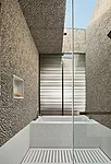 Pebble wall tiles in a child’s bath emphasize the interplay of light and shadow. They envelop a custom solid-surfacing tub surround carved with nicknames, as well as a slotted solid-surfacing dr
