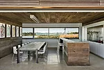 Oak dominates the kitchen, save for white lacquer cabinetry that conceals appliances and frames a stainless-steel backsplash.