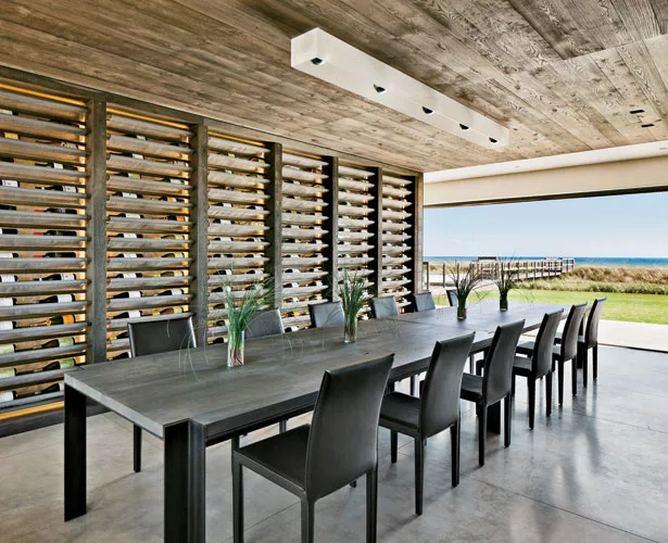 Flooring throughout is poured concrete. For the custom wine rack, the architects used mirror-glass to capture reflections of movement, while long swaths of mesh fabric hold the bottles. The custom cei