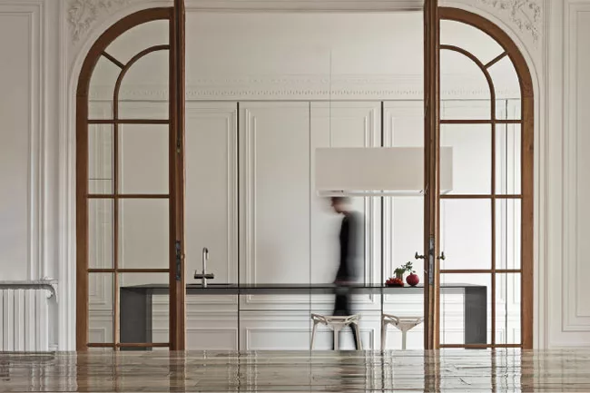 In a Paris apartment, i29 Interior Architects concealed most of the kitchen behind MDF doors covered in decorative panels.