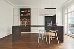 Double doors open out and tuck away to reveal appliances and a workstation. The suspended light fixture is also a ventilation hood.
