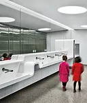 Undulating sink troughs composed of white solid surfacing are striking new additions to the updated washrooms at the Royal Ontario Museum. In the women’s room, the surfacing also wraps a diaper 