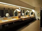 A snapshot of the original bathrooms reveals dated laminate counters and a tan-brown palette.