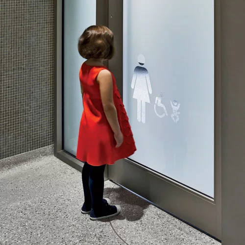 Cutouts in translucent film on the glass entry doors act as wayfinding markers; their placement at child’s-eye level helps maintain privacy.