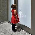 Cutouts in translucent film on the glass entry doors act as wayfinding markers; their placement at child’s-eye level helps maintain privacy.
