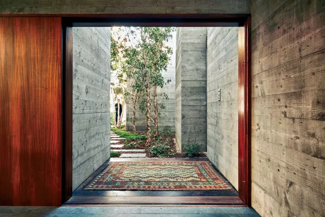 The fine grain of Douglas fir formwork adds texture to concrete walls, which continue on the inside of the main entry from the outside.