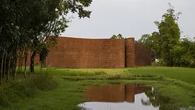 an undulated brick wall in a rural landscape