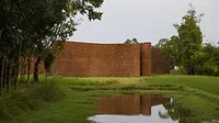an undulated brick wall in a rural landscape
