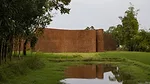 an undulated brick wall in a rural landscape