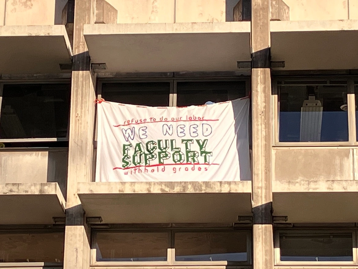 a strike sign hanging from an academic building.