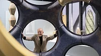 norman foster poses with a fly's eye dome prototype at an exhibition