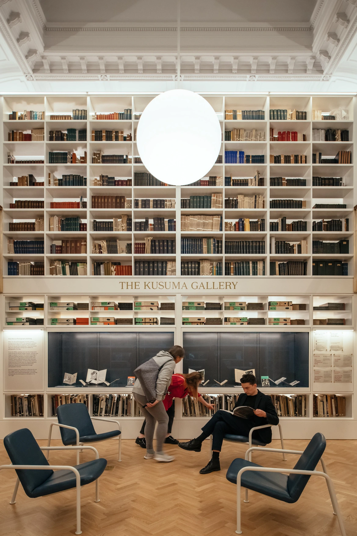 people gather in a museum library space